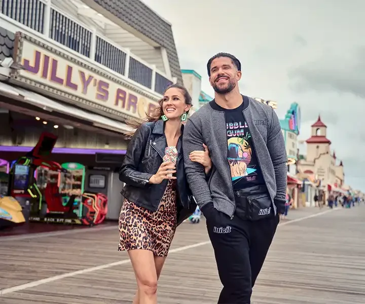 Illicit Gardens - Two people walking together in Illicit Garden branded clothing on a boardwalk